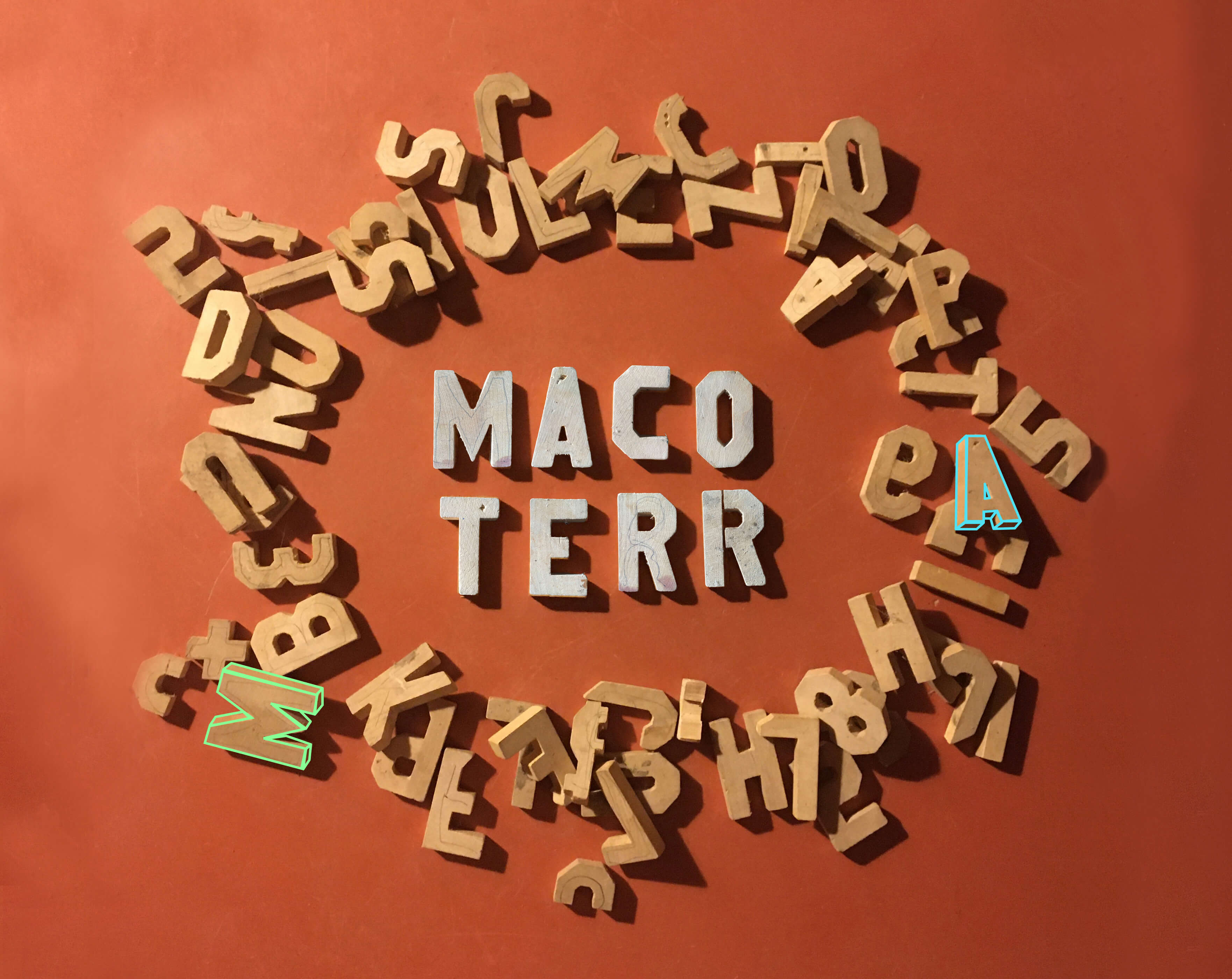 Pile of wooden block letters lying on an orange floor.